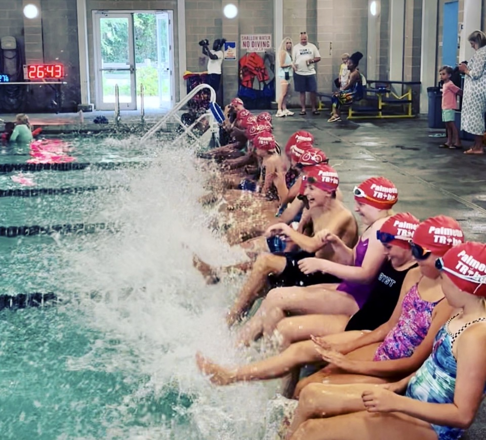 Children sitting near a swimming pool in costumes